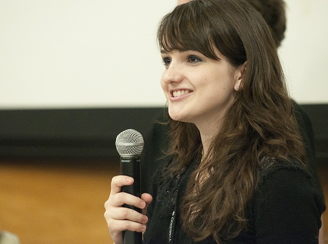 Image of a young women speaking into a microphone